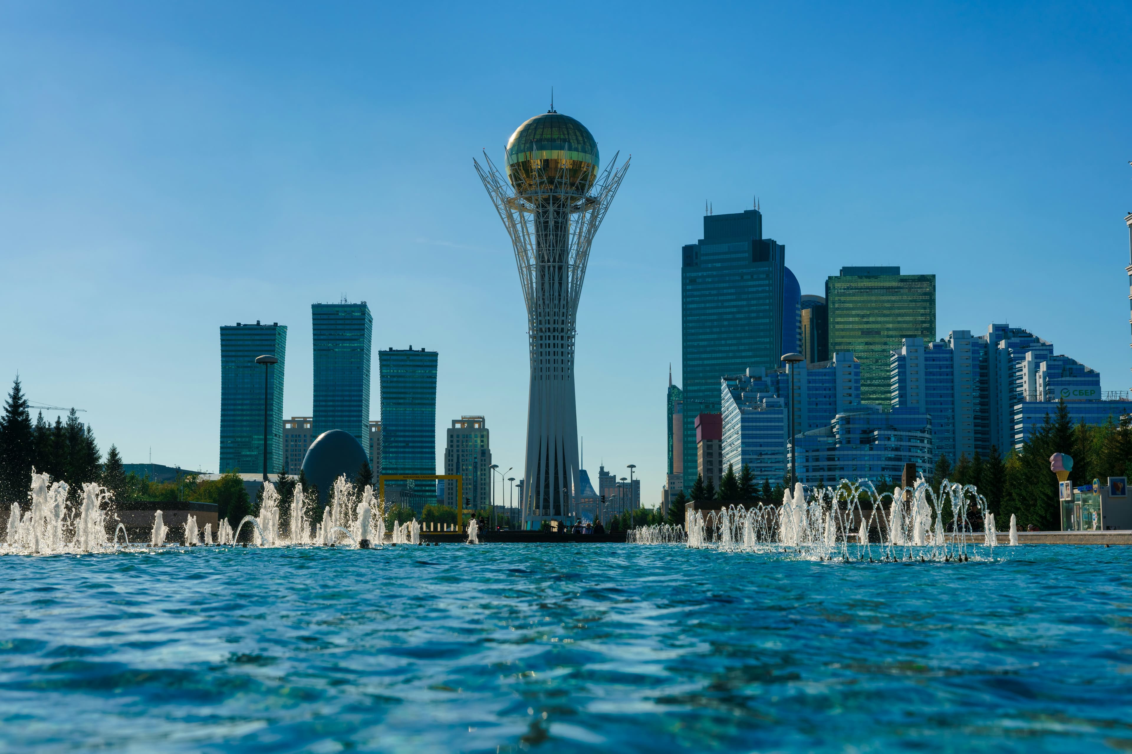 The futuristic skyline of Astana featuring the Bayterek Tower at sunset